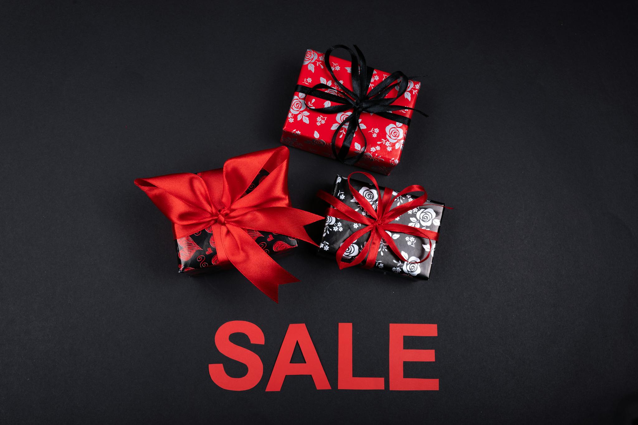 Stylish gift boxes with red ribbons on sale. Perfect for promotions and festive occasions.